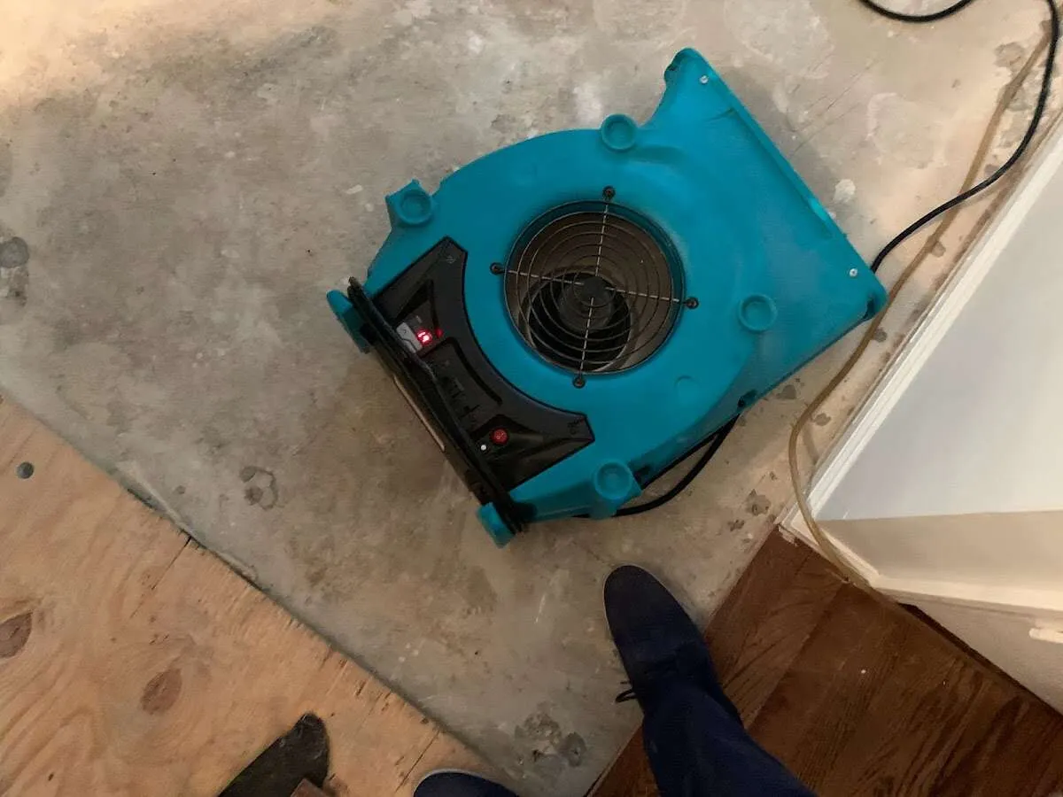 Air mover drying subfloor during Leak Detection & Repair in Keokuk